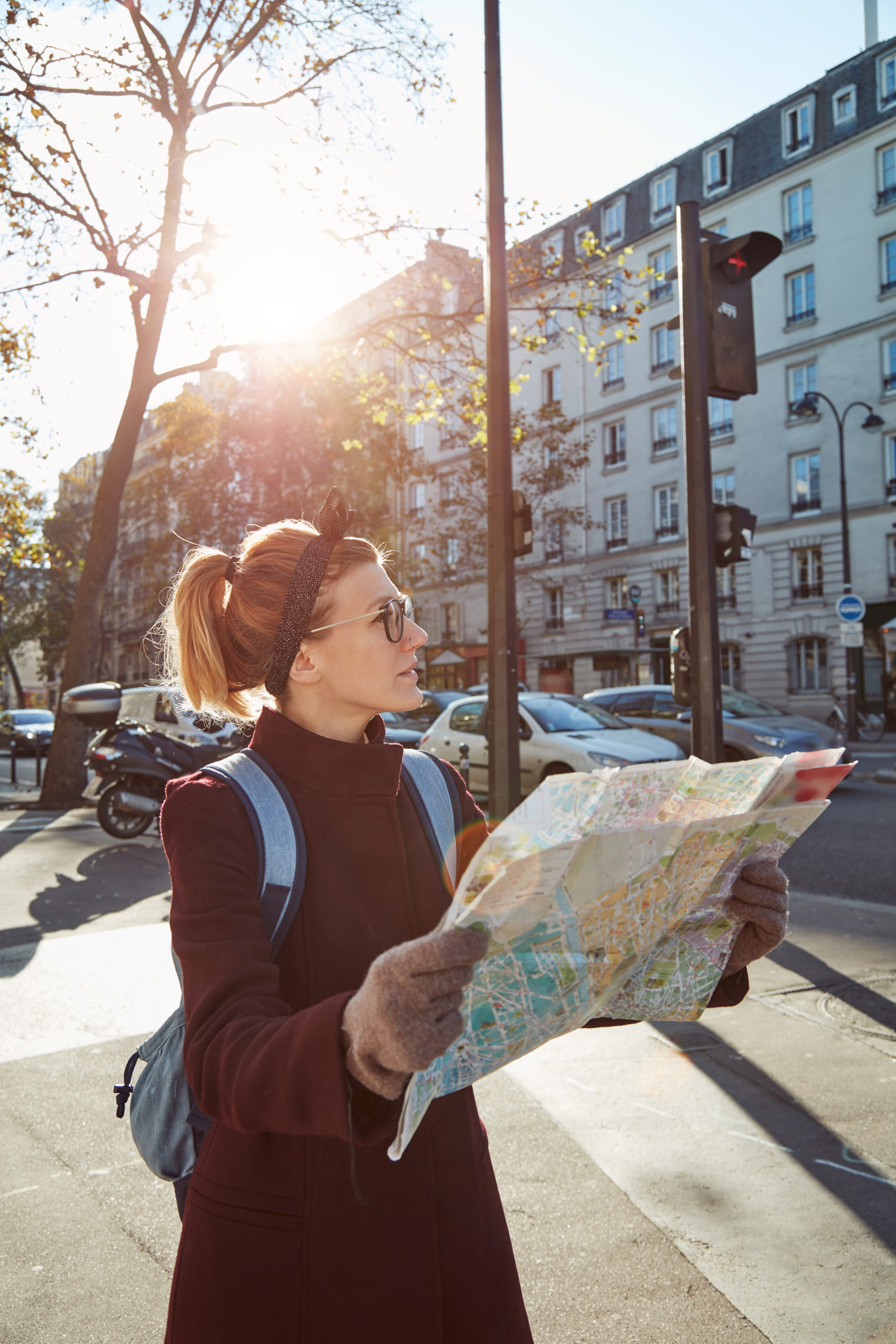 Woman tourist using city map in Paris streets, France.